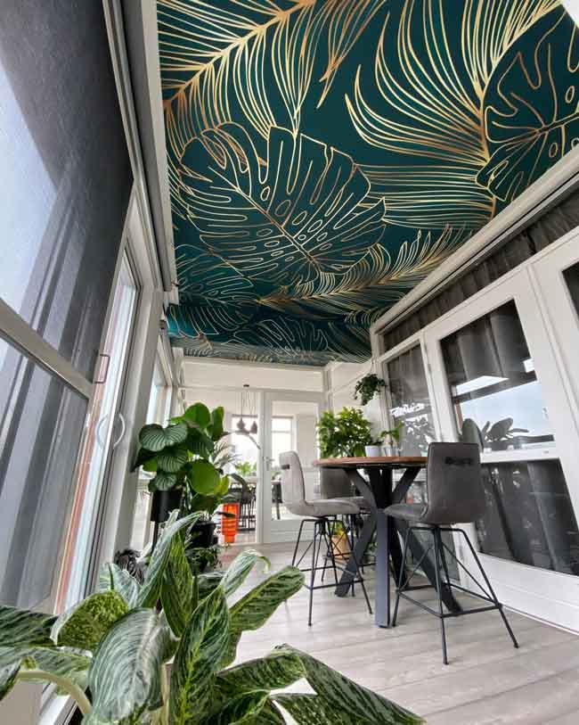 Wallpaper of tropical leaves applied on a ceiling for a fresh, green look